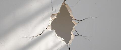 A hole in a wall with a crack in it photo
