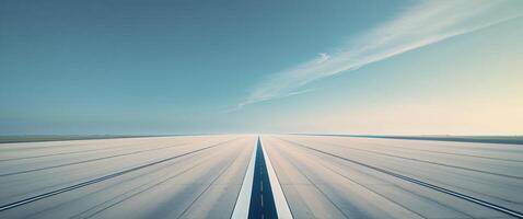 An empty runway with a blue sky in the background photo