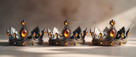 Three Ornate Crowns with Glowing Amber Jewels photo