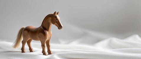 Small wooden toy horse with a natural finish resting on a white backdrop photo