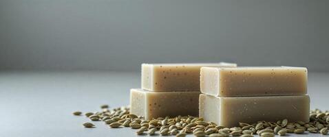 Three hemp seed soap bars stacked with scattered seeds around. photo