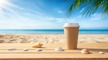 Coffee cup on wooden table with seashells and palm tree on the beach photo