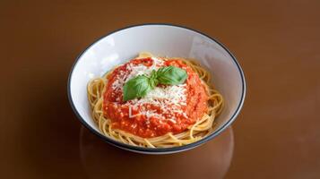Spaghetti with tomato sauce and basil on brown background photo
