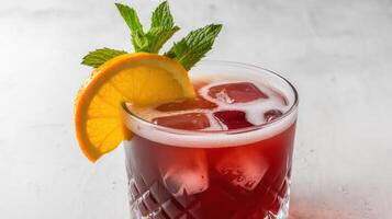 A red drink with an orange slice and mint photo