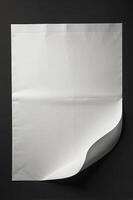 Blank White Paper Sheet with Curled Corner on Dark Background Studio Shot photo