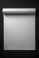 Blank Rolled White Paper Sheet on Black Backdrop for Graphic Design photo