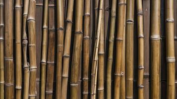 Bamboo Stalks Arranged Vertically Against a Brown Wooden Background Texture photo