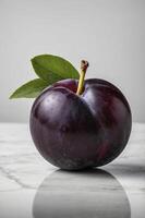 Fresh Plum Still Life on Marble Surface with Leaf Accent photo
