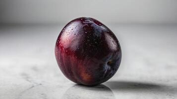 Ripe Plum Still Life with Water Droplets on a Light Surface photo