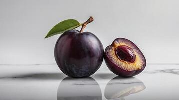 Fresh Plums with Half Cut Plum on Reflective Surface Still Life photo
