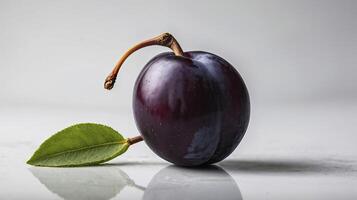 Ripe Plum Still Life with Leaf on Reflective Surface Close-up photo