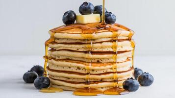 A stack of pancakes with blueberries and syrup photo