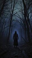 Mysterious Figure in Dark Cloak Standing in Foggy Forest at Night photo