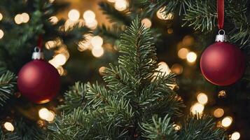 Hanging Red Christmas Ornament on Pine Tree with Festive Lights photo