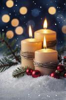 Burning Candles with Festive Christmas Decorations in Snow and Bokeh Lights photo