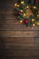 Festive Christmas Wreath with Lights and Ornaments on Dark Wood Background photo