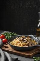Serving Spaghetti with Mushrooms and Tomatoes on Wooden Board with Olive Oil photo