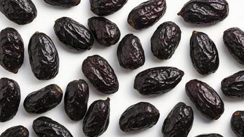 Dark Dates Scattered on White Surface Ready for Cooking or Snacking photo