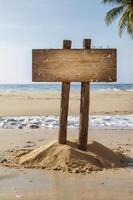 Wooden Sign on Sandy Beach with Ocean Backdrop and Palm Tree photo