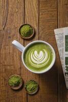 Enjoying Matcha Latte Art Drink on Rustic Wooden Table Top photo