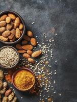 Assorted Nuts and Spices in Bowls on Dark Textured Background photo