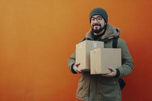 Smiling Man Carrying Cardboard Boxes Against Orange Wall for Delivery photo
