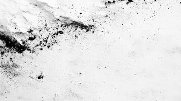 Black Powder Splatter on White Surface Creates Dramatic Abstract Texture photo