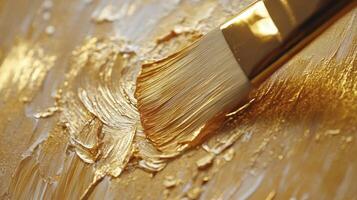 Applying Golden Paint with a Brush for Textured Art Effect photo