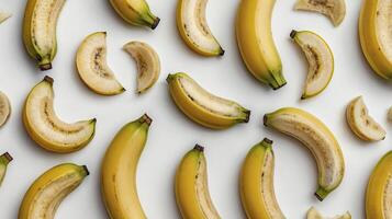 Arrangement of Whole and Sliced Bananas on White Background for Food Photography photo