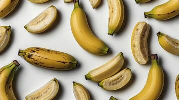 Ripe Bananas Arranged on White Background with Whole and Sliced Fruits photo