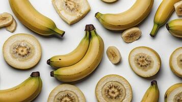 Arrangement of Whole and Sliced Bananas on a White Background photo