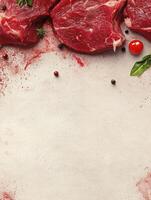 Raw Beef Steaks with Spices and Herbs on Rustic Background photo