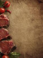 Raw Beef Steak with Tomatoes and Spices on Rustic Paper Background photo