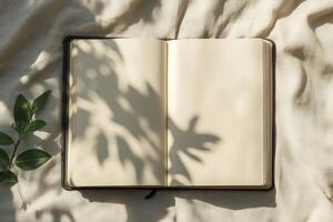Open Notebook with Blank Pages and Leaf Shadows on Beige Fabric photo