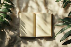 Open Notebook on Fabric with Plant Leaves and Leaf Shadow Overlay photo