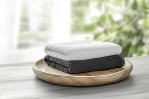 Stack of Folded Towels on Wooden Tray with Bright Window Background photo