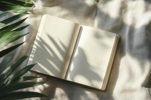 Open Notebook on Fabric with Palm Leaf Shadows for Creative Writing photo