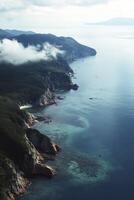 Aerial View of Rugged Coastline with Cliffs, Forest and Clear Turquoise Water photo