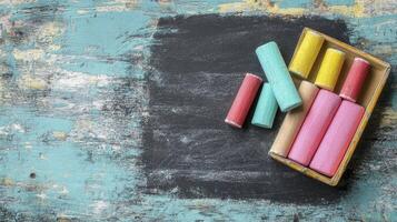 Colorful Chalks on Blackboard with Rustic Wood Texture and Empty Space photo