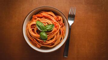 A bowl of spaghetti with tomato sauce and a fork photo