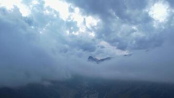 Aerial view of misty mountain valley with clouds and rugged peaks video