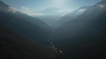 Aerial view of a misty valley with river and distant peaks video