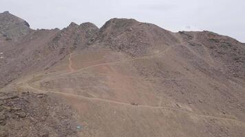 Hikers traversing a rugged mountain path near the summit video