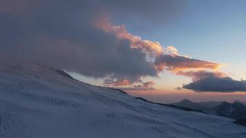 Snow-covered slopes of Elbrus under a colorful evening sky video