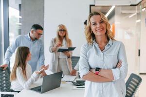 With notepad... Analyzing data. Group of professional business people is in the office photo