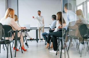 Man ,is teaching and making master class. ,Group of professional business people is in the office photo