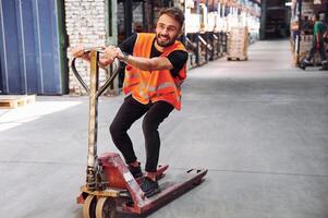 On the trolley platform.. Storage worker is in the warehouse with bunch of products photo