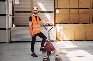 Trolley platform. .Storage worker is in the warehouse with bunch of products photo