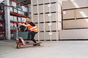 On the trolley platform. Storage worker is in the warehouse with bunch of products photo