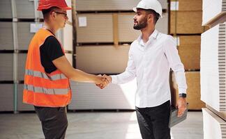 Standing together.. Two storage workers is in the warehouse photo